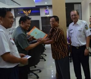 F-Kepala BPN Kota Tangerang Himsar menerima sertipikat tanah dari Musran Sobari, warga Poris Plawad penerima uang ganti rugi lahan proyek kereta api Bandara Soetta, Jumat 13 Mei 2016-Uis SatelitNews